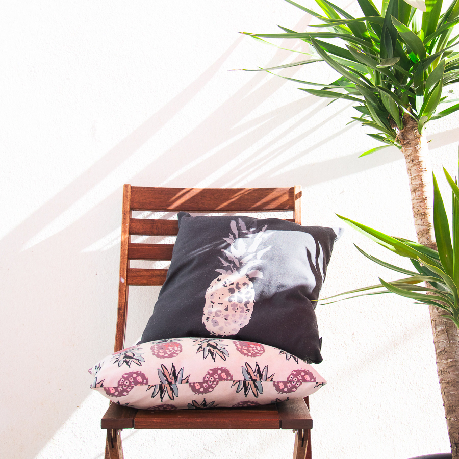 two throw pillows, a chair and a plant - designsoup by alix