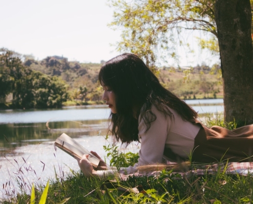 Relaxing Getaways - girl reading book in nature- ASMALLWORLD